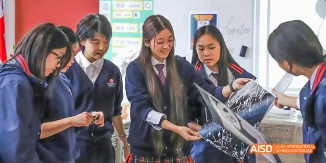Students in uniform working on a science experiment in a classroom at Dipont KCS Chengdu.