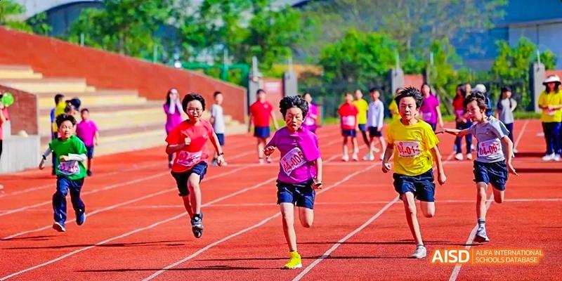 Dipont KCS Chengdu students run a race on an outdoor track during a sports day event.