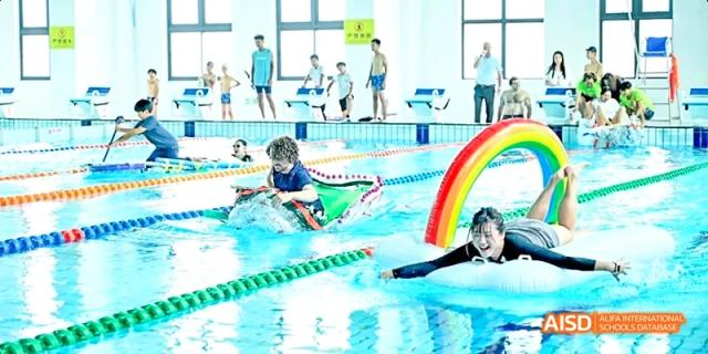Dipont KCS Chengdu students compete in a swimming race in an indoor pool.