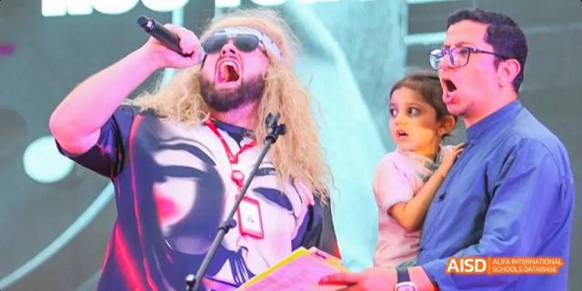A Dipont KCS Chengdu student with a painted face and a wild wig sings or shouts during a performance.