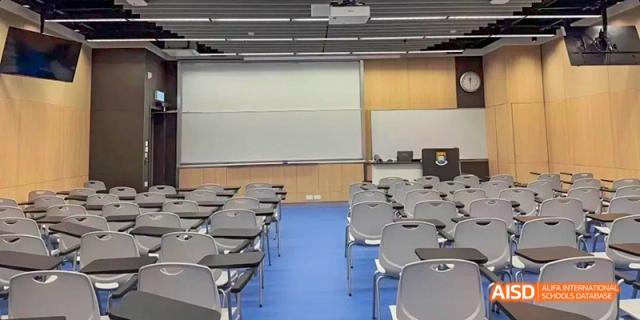 An empty Ealing International School classroom with rows of desks and chairs.
