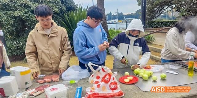 Ealing International School students are at an outdoor event, preparing food.
