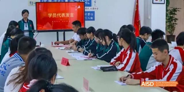 A group of students in uniforms seated at a long table and studying in a classroom at Fuzhou Concord College of Sino-Canada.