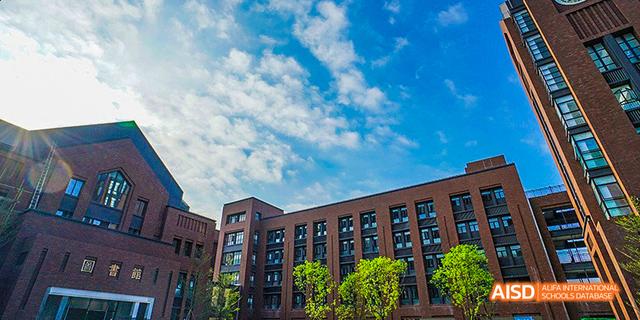 The exterior of a school building under a beautiful blue sky with scattered clouds at Fuzhou Concord College of Sino-Canada.