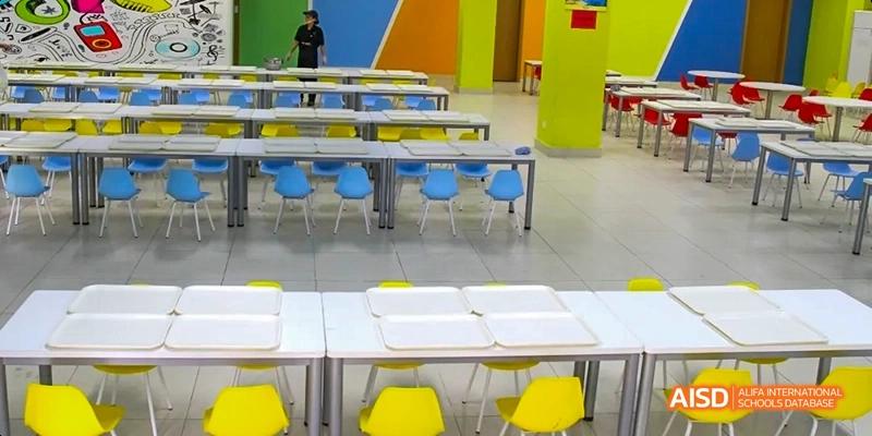 An empty cafeteria with blue and yellow chairs at Fuzhou Concord College of Sino-Canada.