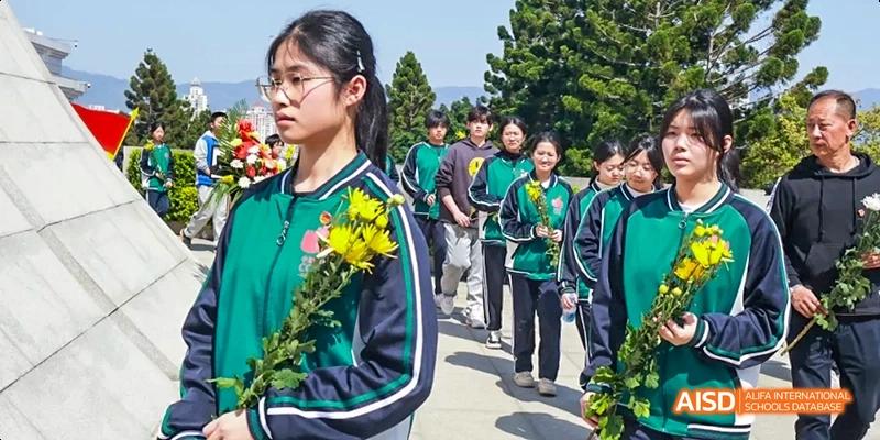 Students walking in a group, with one holding a bouquet of flowers, at Fuzhou Concord College of Sino-Canada.