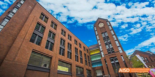 A modern brick building on the campus of Fuzhou Concord College of Sino-Canada under a bright blue sky.