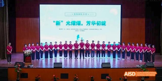 A large group of students in red uniforms standing on a stage during a school event at Fuzhou Concord College of Sino-Canada.