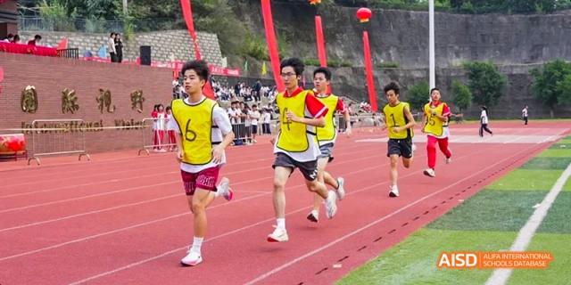 Athletes running a race on a red track, some wearing yellow jerseys, at Fuzhou Concord College of Sino-Canada.