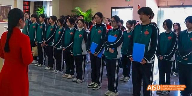 A group of students in green and blue uniforms walking together on the Fuzhou Concord College of Sino-Canada campus.
