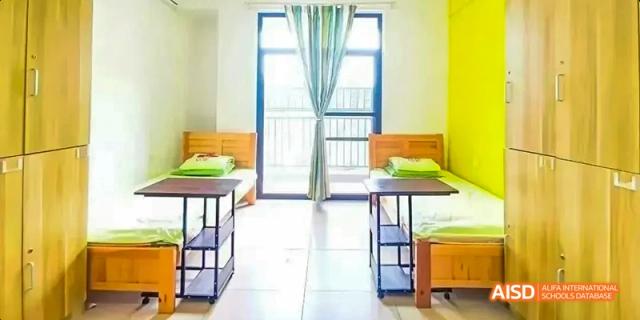Fuzhou Concord College of Sino-Canada - An empty dorm room with two beds and desks positioned next to large windows.