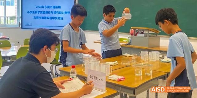 Students from HAIDE Bilingual School Dongguan conducting a science experiment at a table in a classroom.