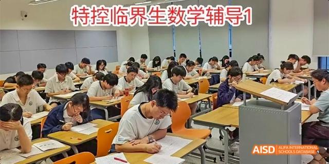 Students from HAIDE Bilingual School Dongguan sitting in a classroom and working on an exam at their desks.