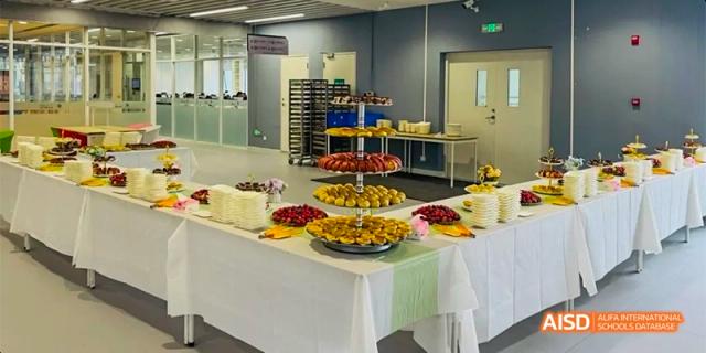A banquet table with a variety of fruits, cakes, and other desserts at a catering event at HAIDE Bilingual School Dongguan.