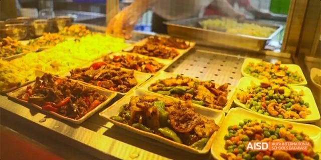 A close-up shot of cooked meat and vegetables on a plate, ready to be served at the cafeteria at HAIDE Bilingual School Dongguan.