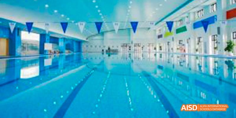 A view of an indoor swimming pool at Harrow LiDe School Haikou with lanes and flags.