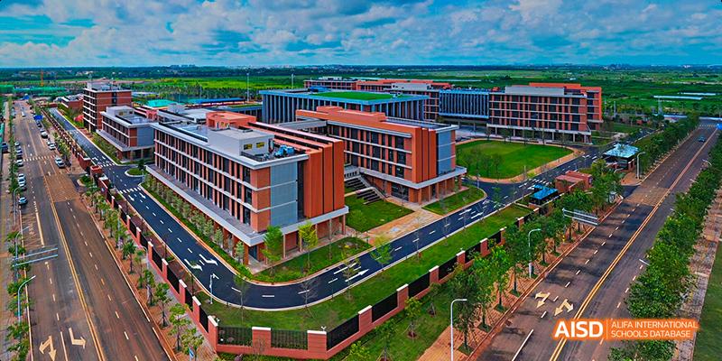 An aerial view of the campus of Harrow LiDe School Haikou, showcasing modern buildings, roads, and green spaces.