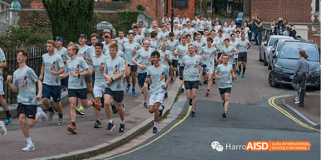 A large group of students from Harrow LiDe School Haikou participate in a cross-country run or race.