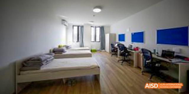 A view of a student dormitory room at Harrow LiDe School Haikou with two beds and desks.