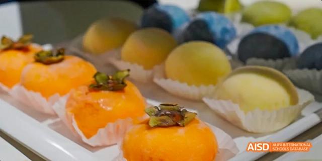Small, round yellow cakes with fruit toppings, likely from a school event at Harrow LiDe School Haikou.