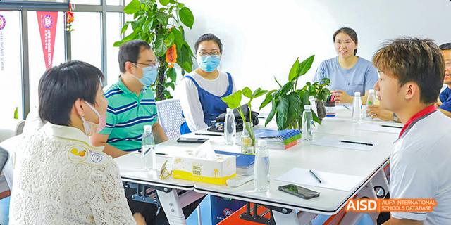 A Hefei Thomas School student wearing a lab coat and safety glasses while conducting an experiment.