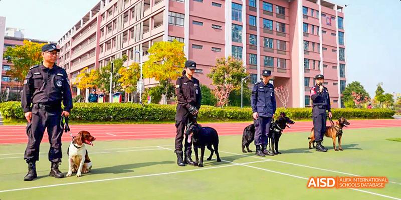 A security guard with a police dog on a sports field at Hefei Thomas School.