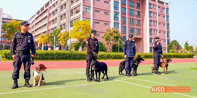 A security guard with a police dog on a sports field at Hefei Thomas School.