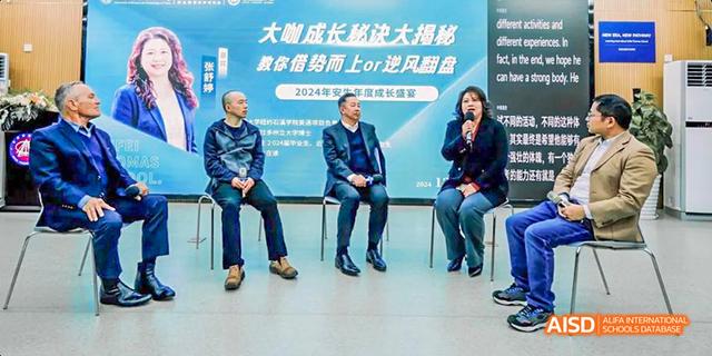 An official from Hefei Thomas School sitting on a stage with a banner behind him that reads "Growth Challenge."