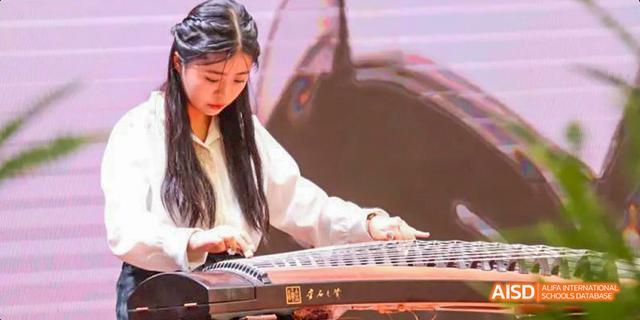 A close-up of a student from the International Department of Chengdu Shude High School skillfully playing the traditional Chinese instrument, the guzheng (zither).