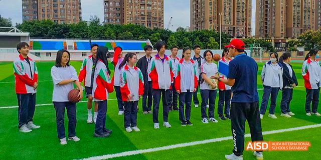 Students from the International Department of Chengdu Shude High School standing in uniform on a field during a sports event.