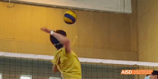 A student from the International Department of Chengdu Shude High School hitting a volleyball over a net during practice.