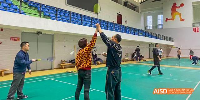 A high-five between two participants from the International Department of Chengdu Shude High School after a play during an indoor sports activity.