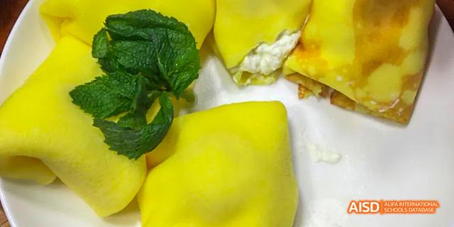 A close-up of a prepared food dish, featuring bright yellow and green wrappers, representing a Health & Nutrition activity at the International Department of Chengdu Shude High School.