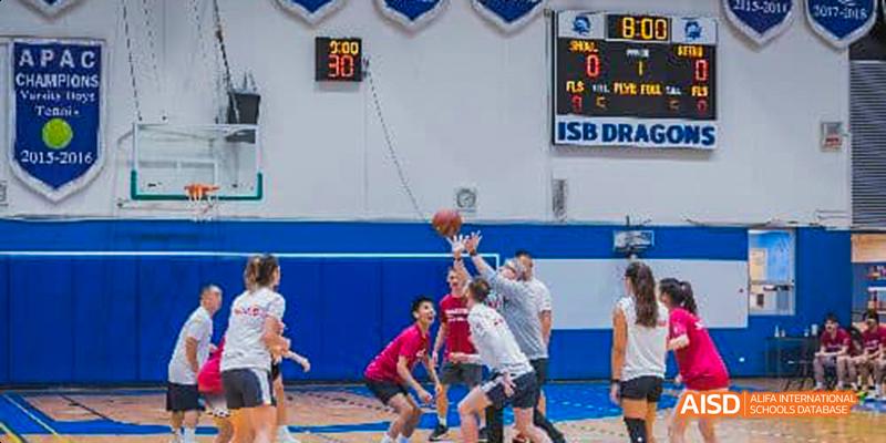 Students and teachers from the International School of Beijing play a casual basketball game in the school gym.
