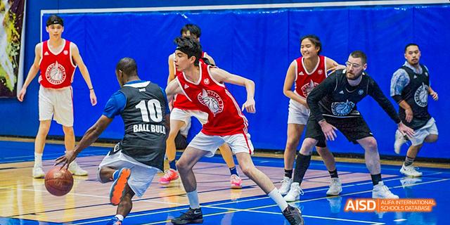 Two students from the International School of Beijing face off during an intense basketball game.