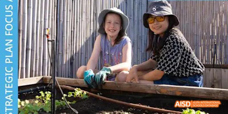 A close-up shot of a student from the International School of Beijing wearing gloves while tending to a garden.