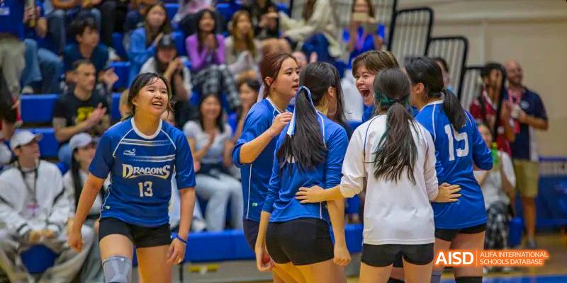 Students from the International School of Beijing are shown in a huddle during a sports event.