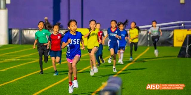 Students from the International School of Beijing participate in a running race on the school track.
