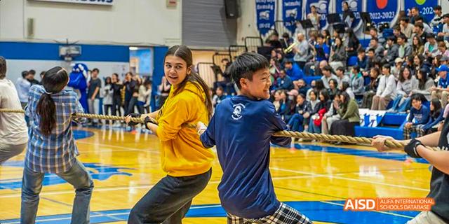Students from the International School of Beijing play a competitive game of basketball in the school gym.