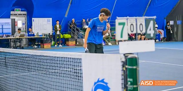 A student from the International School of Beijing runs on a track during a race.