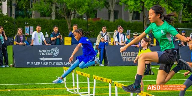 A student from the International School of Beijing competes in a hurdle race.