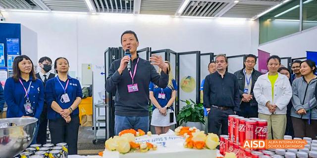 A teacher at the International School of Beijing gives a presentation on food preparation in front of an audience.