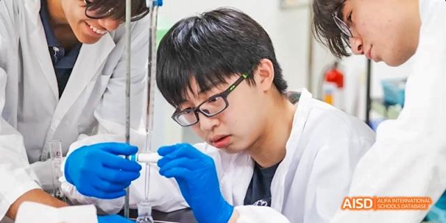 Close-up of an International School of Dongguan student in a lab coat and gloves meticulously conducting a science experiment using glassware.
