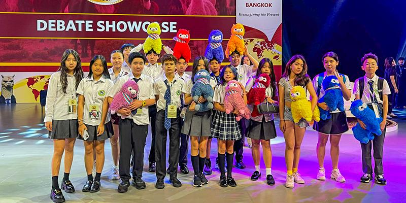 A large, diverse group of International School of Dongguan students poses together on stage after participating in a talent showcase or event.