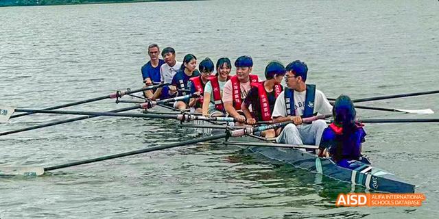 A team of International School of Dongguan students rowing a boat together on the water during a sports club activity.