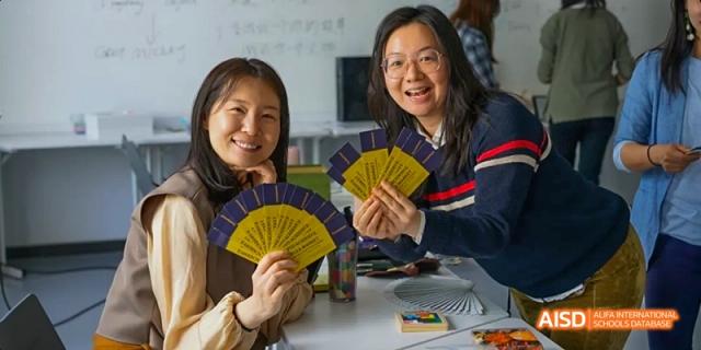 A group of students from JPED Academy, using yellow fans during a classroom activity.