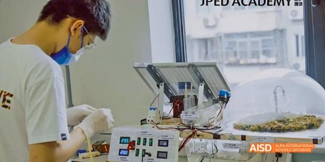 A student from JPED Academy, using a circuit board and wires for a project.