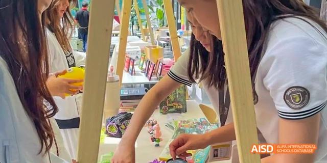 A female student from JPED Academy, working on an art project with colorful materials.