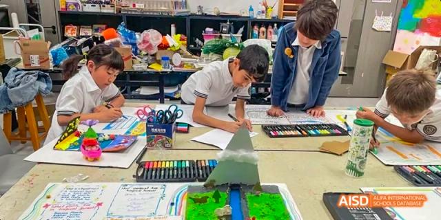 Students from JPED Academy, drawing and working on a project with colorful markers and models.