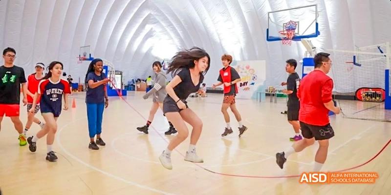 Students from JPED Academy, playing a game of basketball on a court.